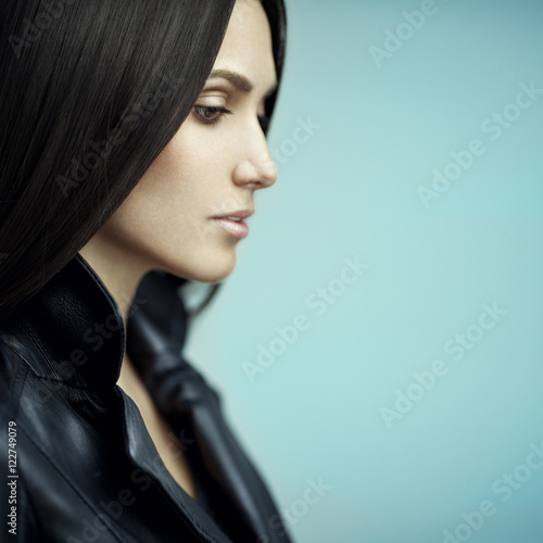 Closeup beauty portrait of beautiful young woman with straight brown hair in a leather jacket. Looking Away. 