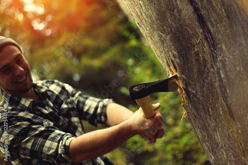 Lumberjack chopping a tree trunk in the forest