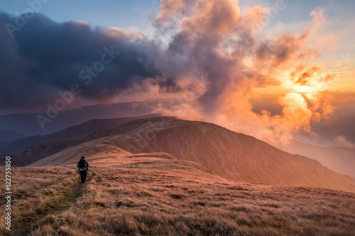 Hiker in mountains at breathtaking sunset