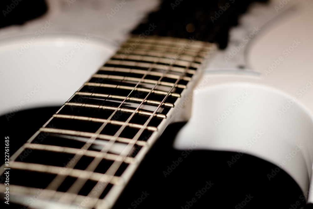 Fototapeta premium Detail of white electric guitar isolated on black background