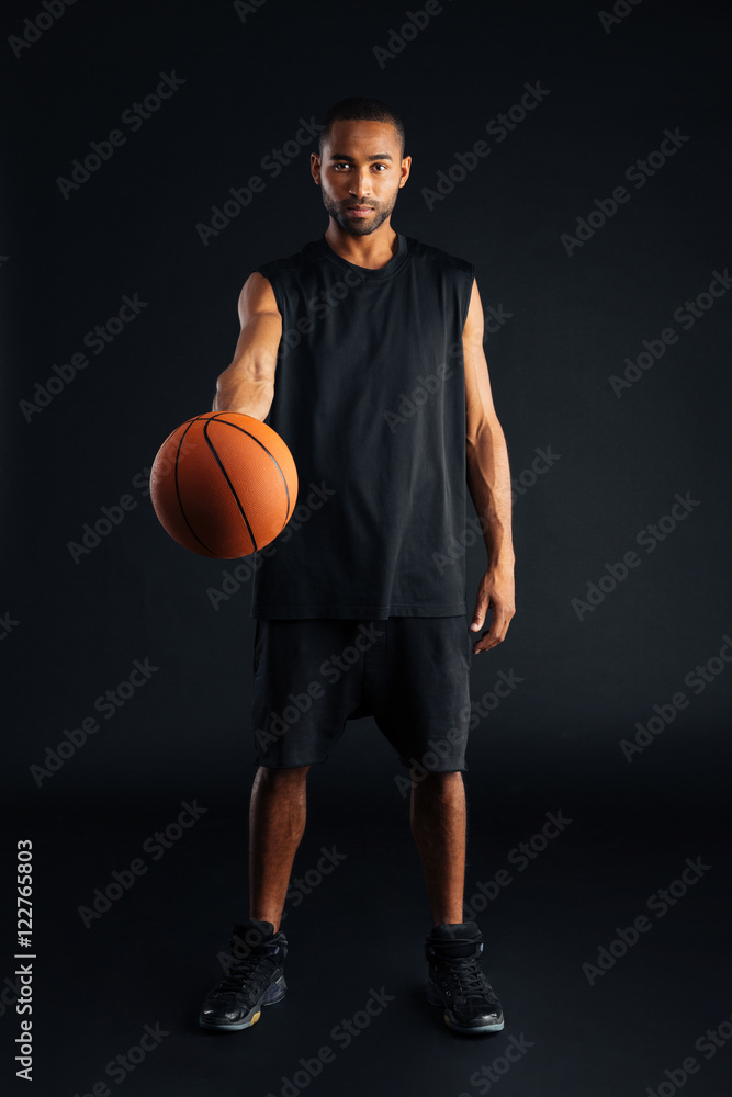 Focused young african basketball player giving ball Focused young african basketball player giving ball
