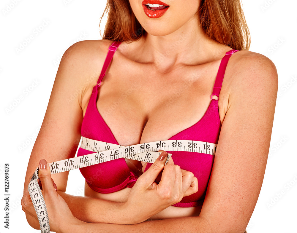 Girl wearing in bra measures her breast measuring tape. Girl wearing her  new silicone breast implants. Stock Photo