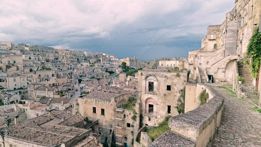 panoramic view of typical stones (Sassi di Matera) and church of Matera under blue sky. Matera in Italy UNESCO European Capital of Culture 2019, dolly camera movement panoramic view of typical stones (Sassi di Matera) and church of Matera under blue sky. Matera in Italy UNESCO European Capital of Culture 2019, dolly camera movement