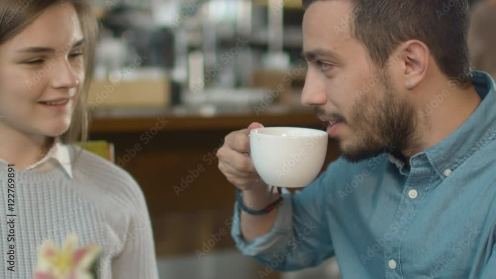 Attractive Young Man and Woman are Sitting Talking at Cozy Coffee Shop. Shot on RED Cinema Camera in 4K (UHD). Attractive Young Man and Woman are Sitting Talking at Cozy Coffee Shop. Shot on RED Cinema Camera in 4K (UHD).