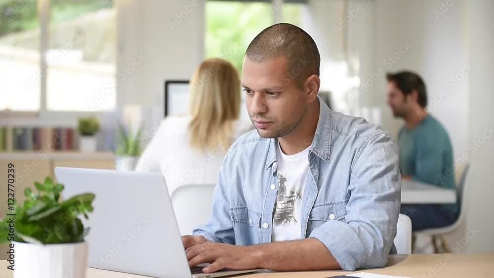Man in office working on laptop computer Man in office working on laptop computer