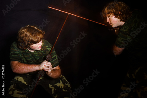 Red-haired freckled fat boy posing like a soldier