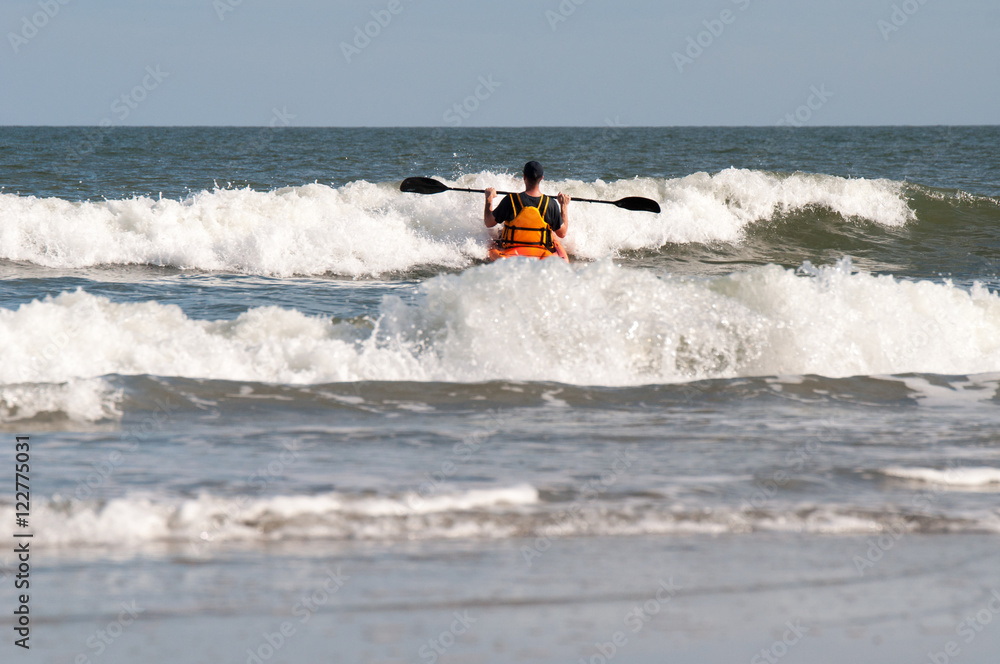 Man having fun kayaking in the ocean waves Man having fun kayaking in the ocean waves