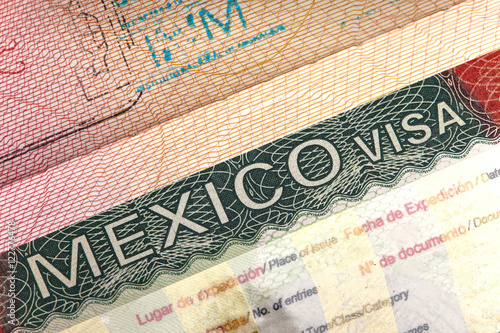 visa of Mexico in the international passport and Mexican pesos, closeup..