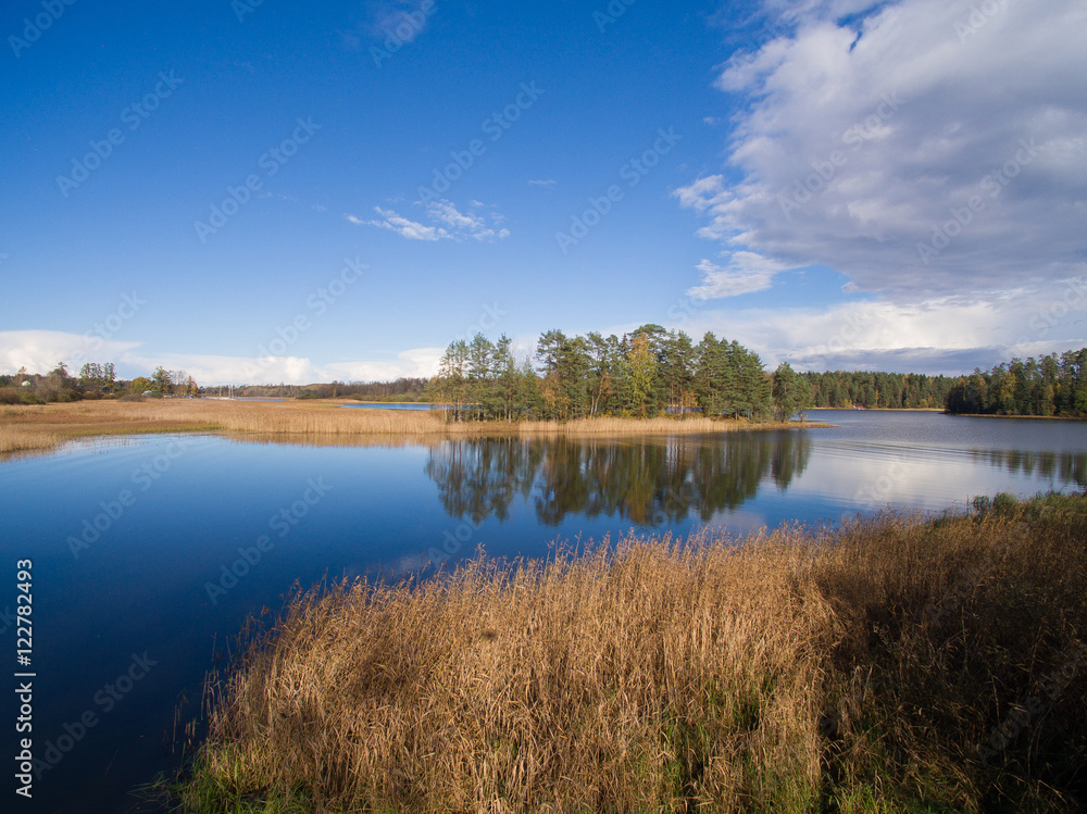 Typical landscape in Karelia - blue sky, clouds, big lake and a lot of distant green islands, trees, stones and rocks Typical landscape in Karelia - blue sky, clouds, big lake and a lot of distant green islands, trees, stones and rocks