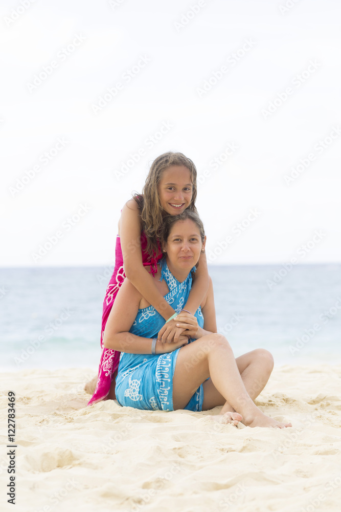 Fototapeta premium Lovely Mother and Girl Sitting on the Beach