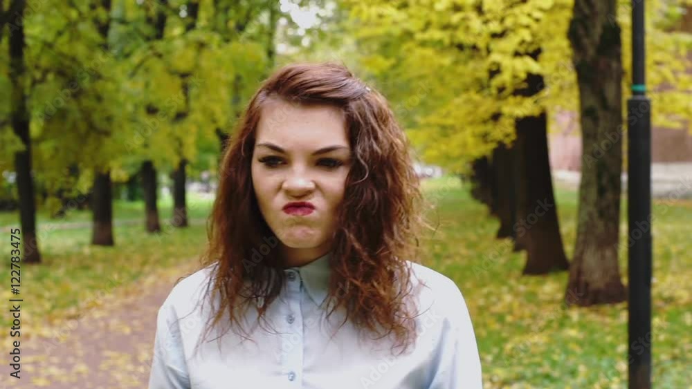 Embarrassed young redhead woman in a park Embarrassed young redhead woman in a park