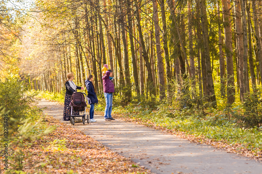 Happy young family walking down the road outside in autumn nature. Happy young family walking down the road outside in autumn nature.