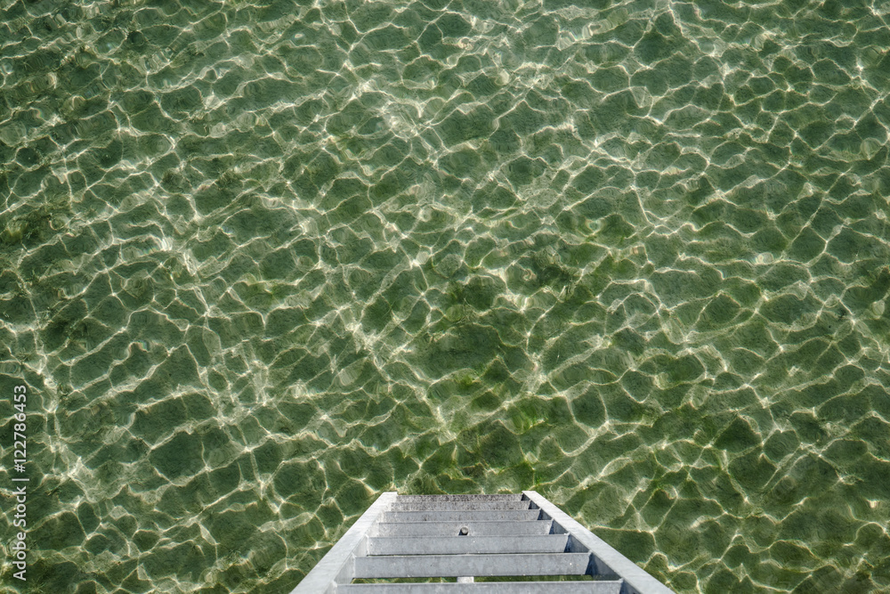 Stegleiter zum Wasser am Bodensee. Wasseroberfläche gekräuselt, Farbe grün