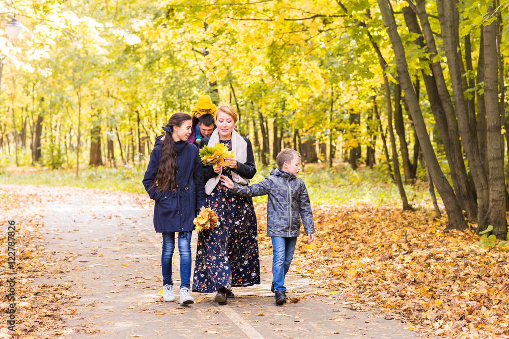 friendly family walking in the park in autumn together friendly family walking in the park in autumn together