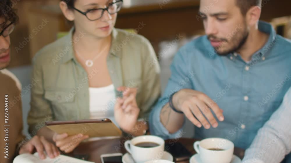 Small Creative Team of Active Young People Having Meeting and Discussion in Coffee Shop. Shot on RED Cinema Camera in 4K (UHD). Small Creative Team of Active Young People Having Meeting and Discussion in Coffee Shop. Shot on RED Cinema Camera in 4K (UHD).