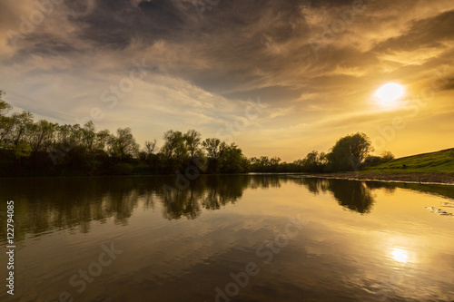 Spectacular sunset reflection in a wild river, in summer