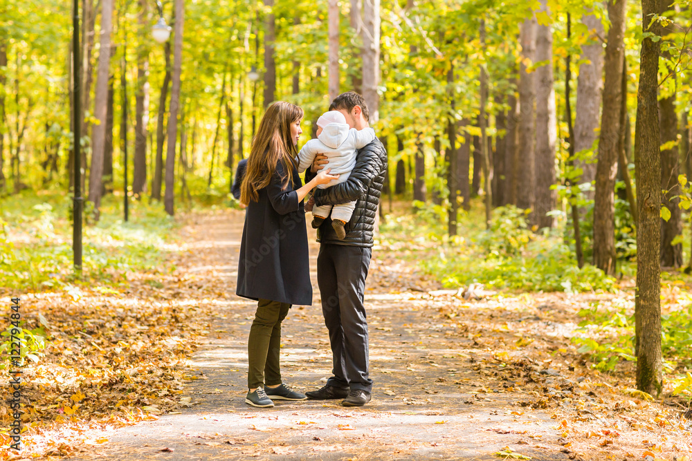 friendly family walking in the park in autumn together friendly family walking in the park in autumn together