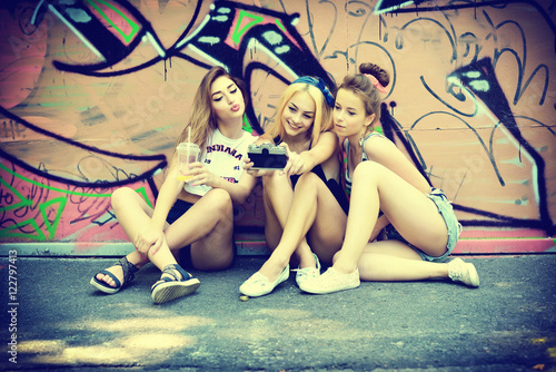 Urban girls have fun with retro vintage photo camera outdoor nea