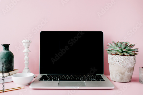 Laptop with black screen on table with proteus flower and decoration