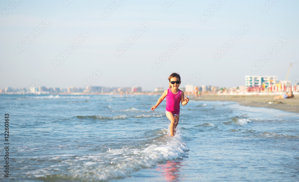 Fototapeta premium Cute child running in the waves