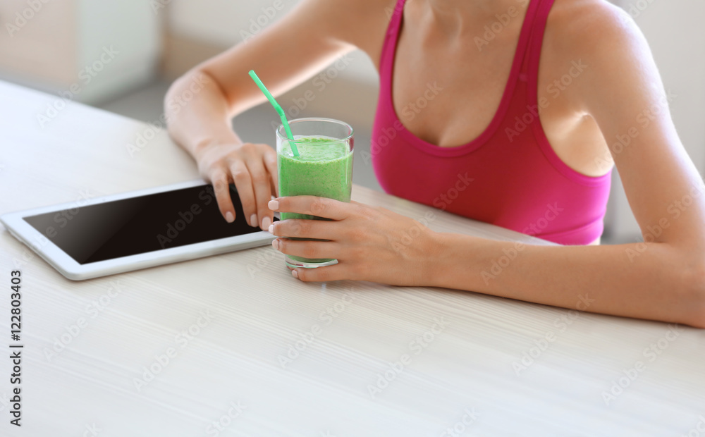 Girl with tablet and smoothie calculating calories on kitchen Girl with tablet and smoothie calculating calories on kitchen