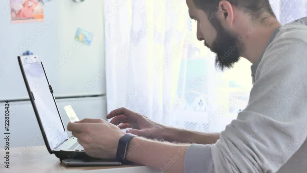 Men entering credit card information into an on-line shopping site. Men entering credit card information into an on-line shopping site.
