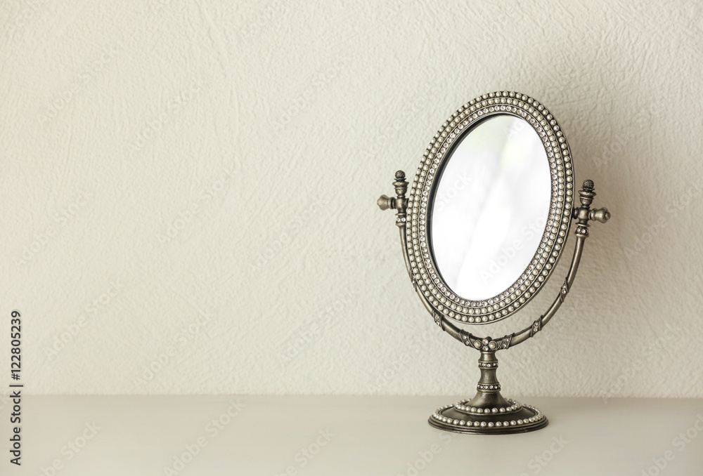 Female mirror on light wall background Female mirror on light wall background