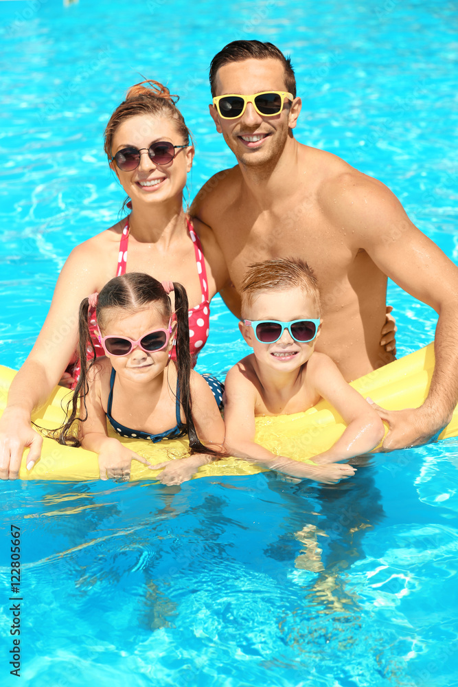 Happy family in swimming pool at water park