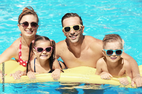 Happy family in swimming pool at water park