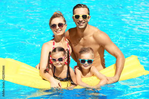 Happy family in swimming po...