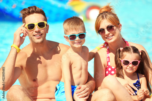 Happy family near swimming pool at water park