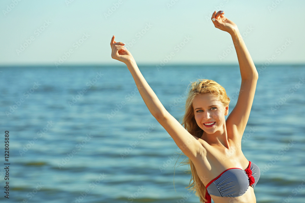 Woman in swimsuit enjoying on sea background Woman in swimsuit enjoying on sea background