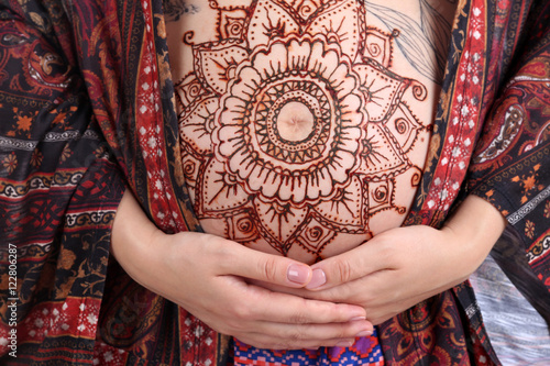 Henna tattoo on pregnant belly, closeup © Africa Studio
