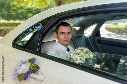Young bridegroom arriving in a car