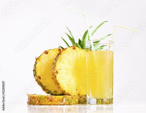 Fresh pineapple juice with sliced pineapple on white background
