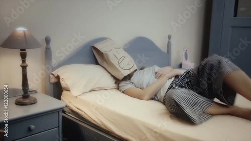 A breadbag face, alone in the bed, having a disturbed sleep, snoring. Medium shot.
 photo