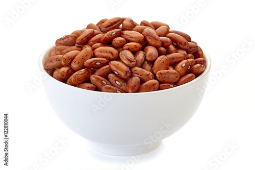 Bowl with pinto beans on white photo