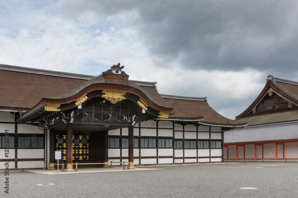 Fototapeta premium Kyoto, Japan - September 14, 2016: Highly decorated wooden entrance fronts the Shinmikurumayose hall at the Imperial Palace. Heavy skies.
