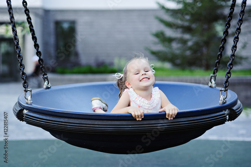 Photos Little girl on swing at the Playground.