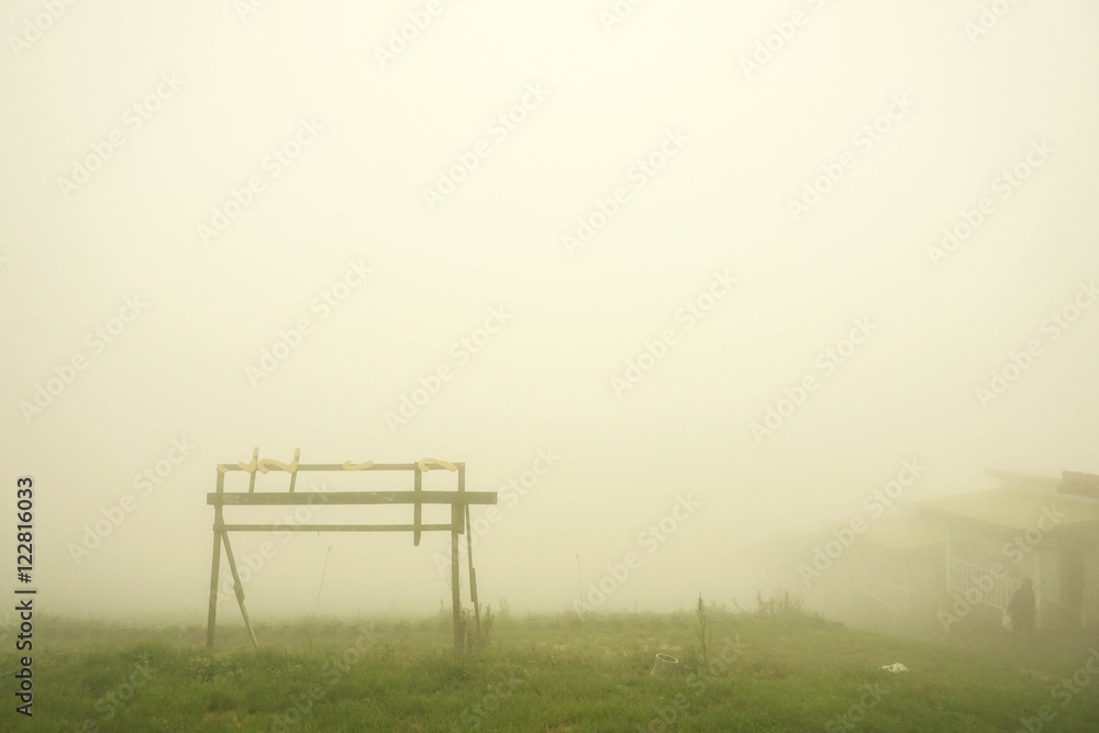 Scenery at foggy hill in Thailand with wear and tear wooden sign