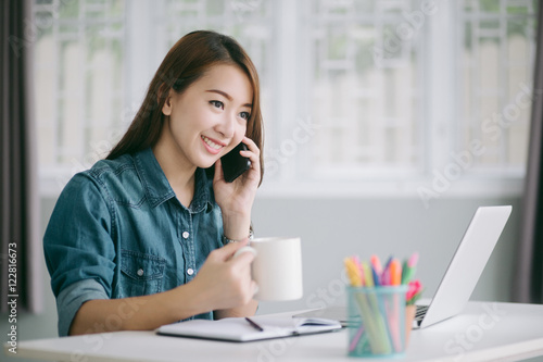 female talking on the phone and hand holding a cup