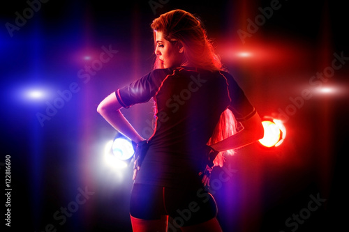 Sports fitness girl on workout in multi-colored rays of fitness room. Beautiful sport girl with long hair. Back view.
