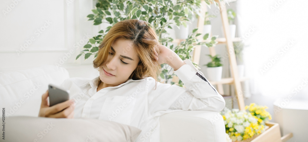 beautiful woman using smart-phone in living room beautiful woman using smart-phone in living room
