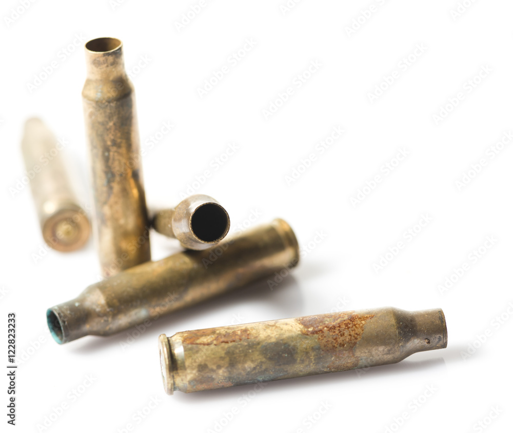 Old and rusty rifle bullets on a white background.