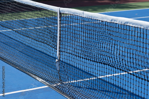A Tennis ball and a racket at blue tennis court. © jumpfl62