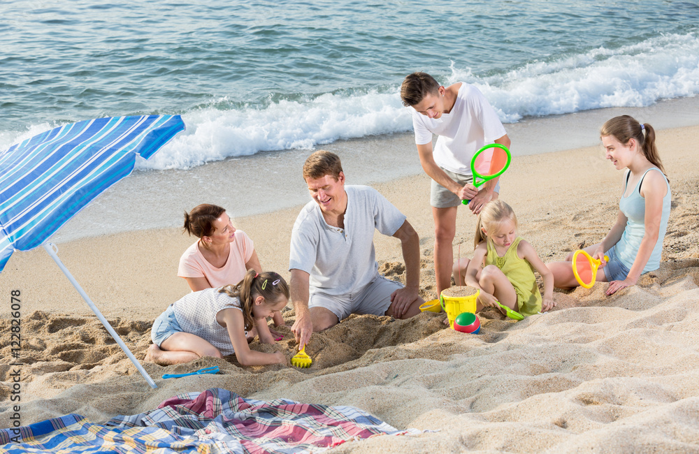 Wunschmotiv: Carefree family of six people playing together on beach #122826078