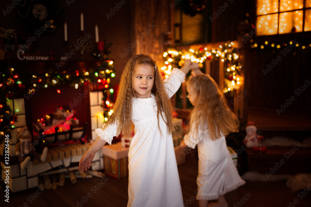 Girls sister friends dancing Christmas tree, concept of Christ Girls sister friends dancing Christmas tree, concept of Christ