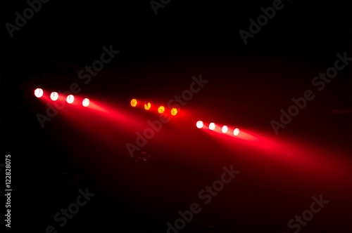 the red color of spotlights in smoke over black background