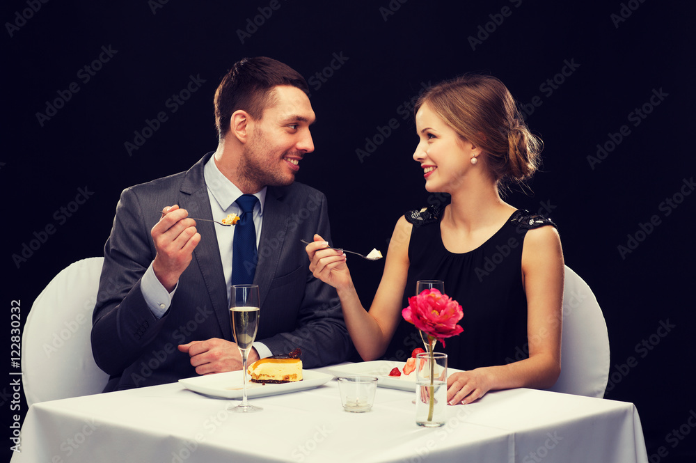 smiling couple eating dessert at restaurant smiling couple eating dessert at restaurant