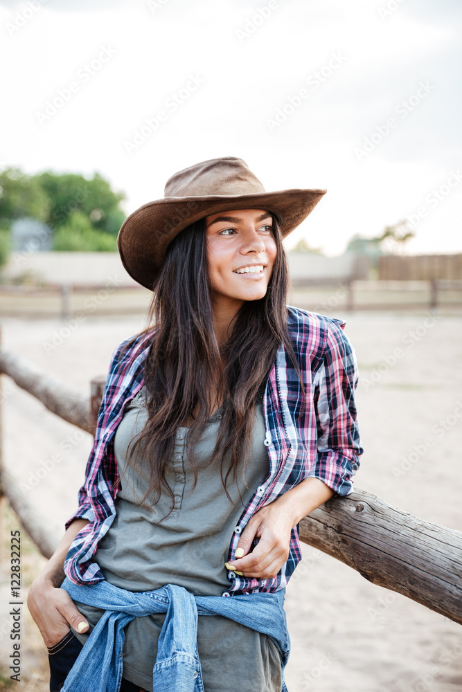Φωτογραφία Happy pretty young woman cowgirl standing near the fence